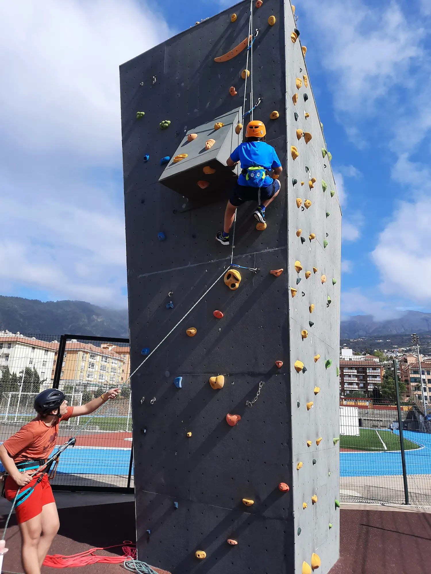 Persona asegurando a un escalador en el club
