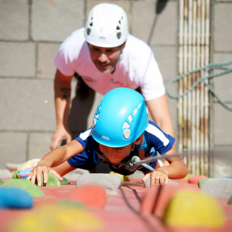 Niño practicando escalada en el rocódromo del club